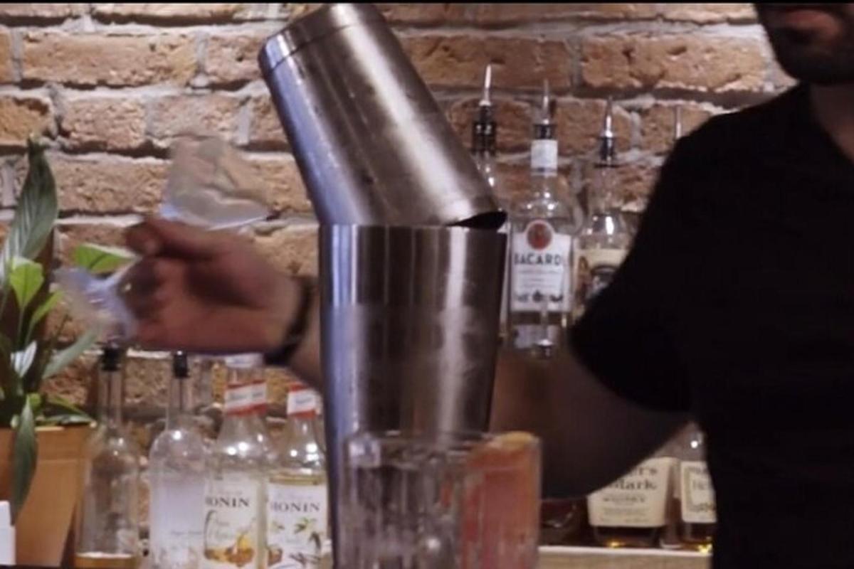 a man is making a drink in a bar
