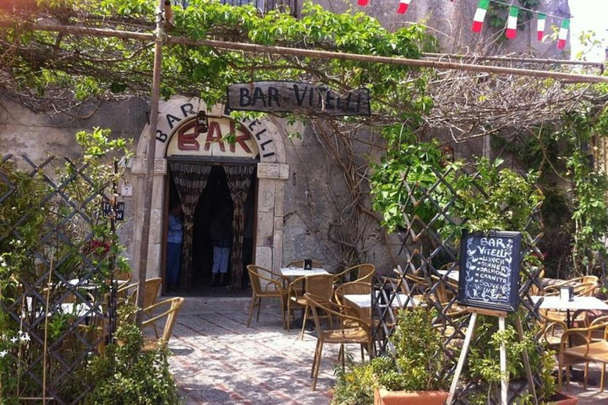 un ristorante all'aperto con tavoli, sedie e un cartello