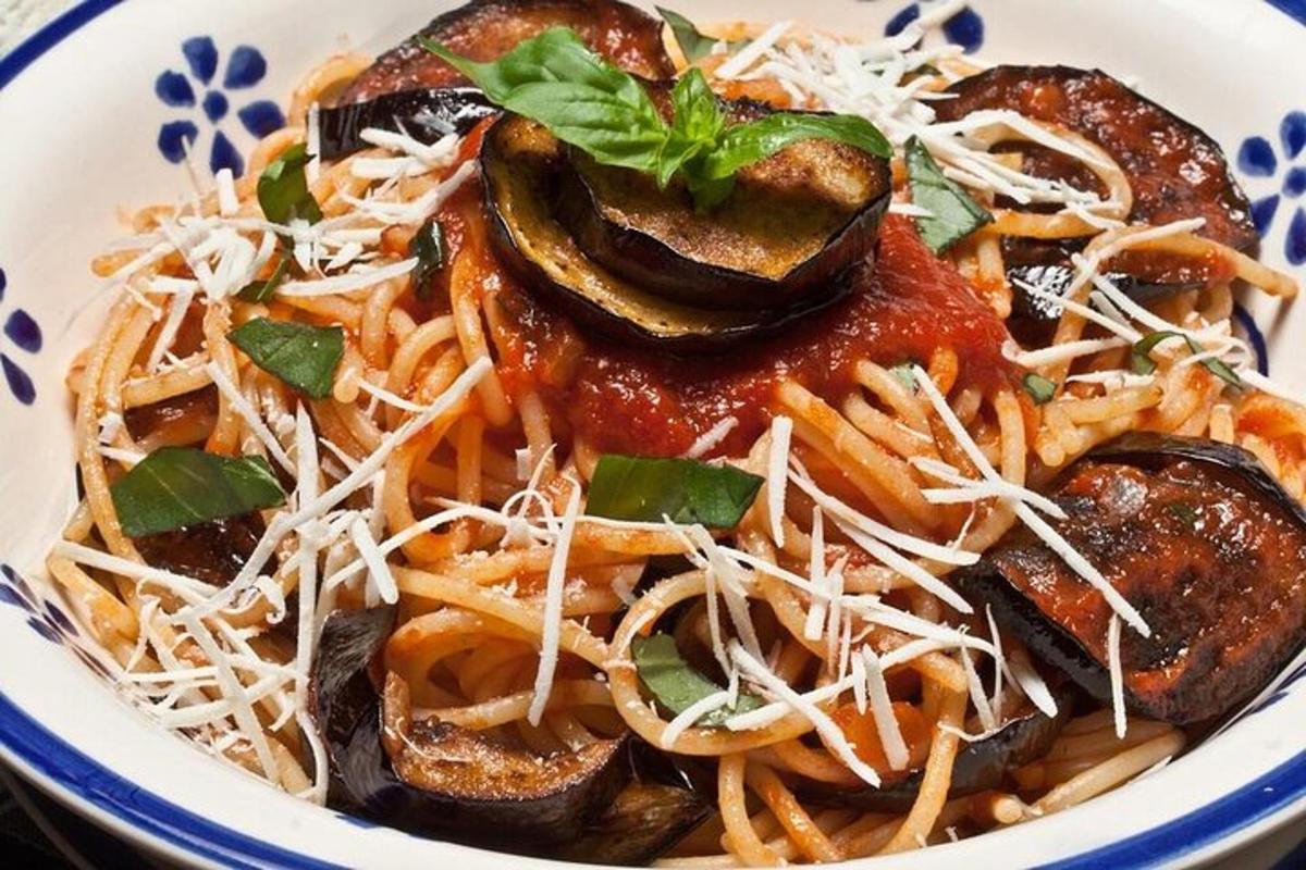 una ciotola di pasta con salsa e verdure su un piatto