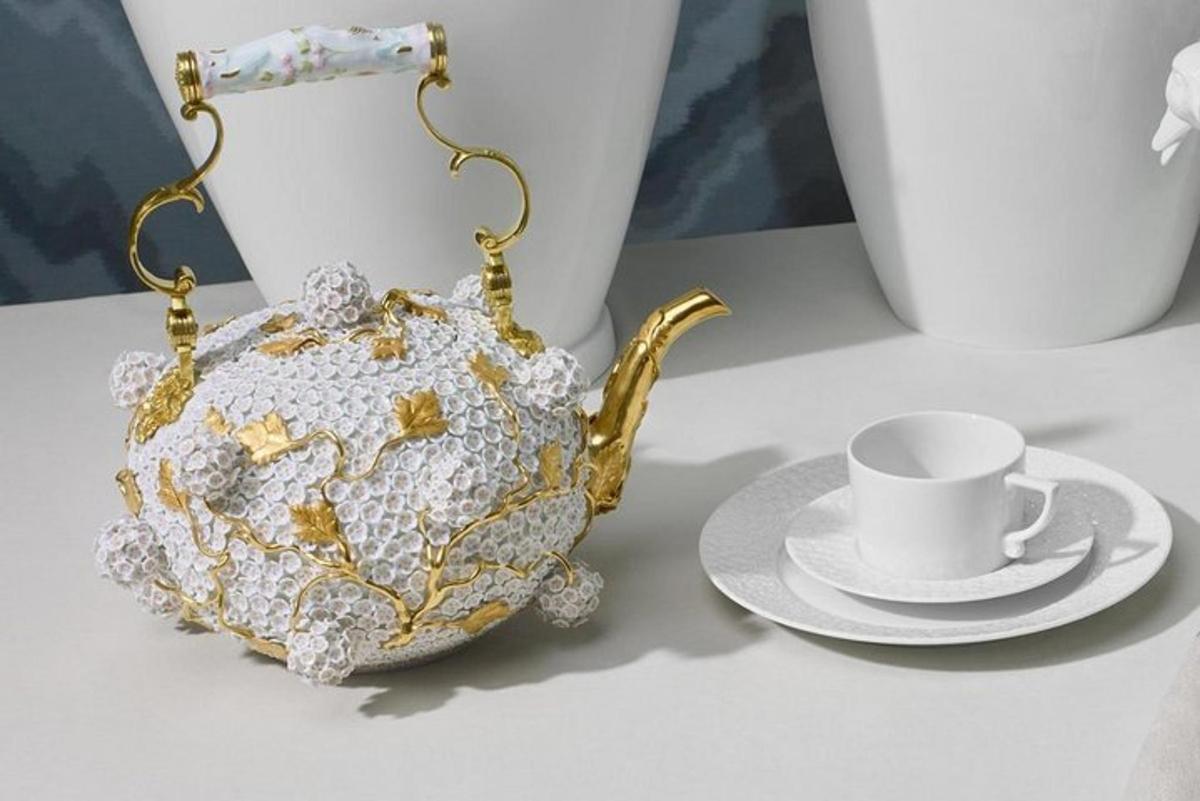 een theepot en een kopje en schotel op een tafel