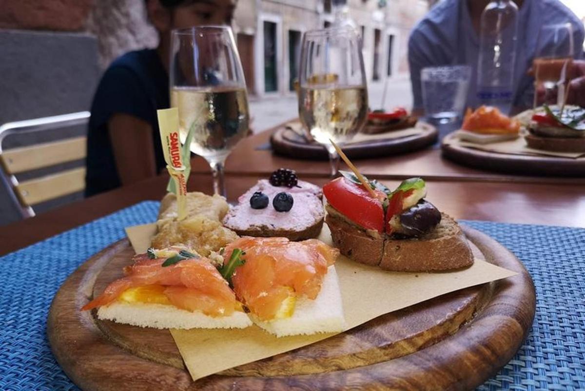a plate of food on a table with glasses of wine