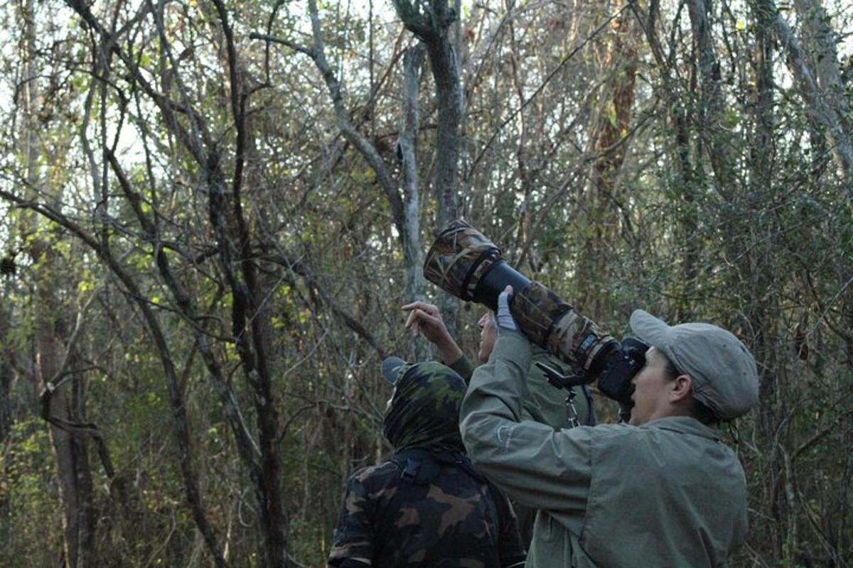 a man taking a picture with a camera in a forest