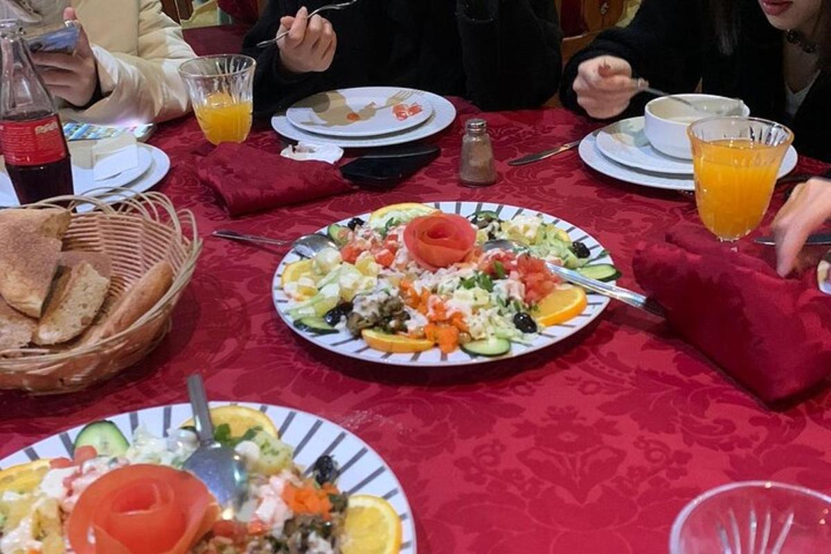 μια ομάδα ανθρώπων που κάθονται σε ένα τραπέζι με πιάτα με φαγητό