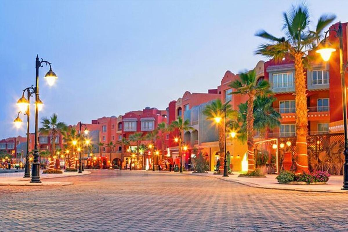 a city street with palm trees and buildings at night