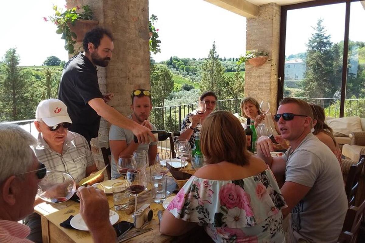 un gruppo di persone sedute attorno a un tavolo con bicchieri di vino