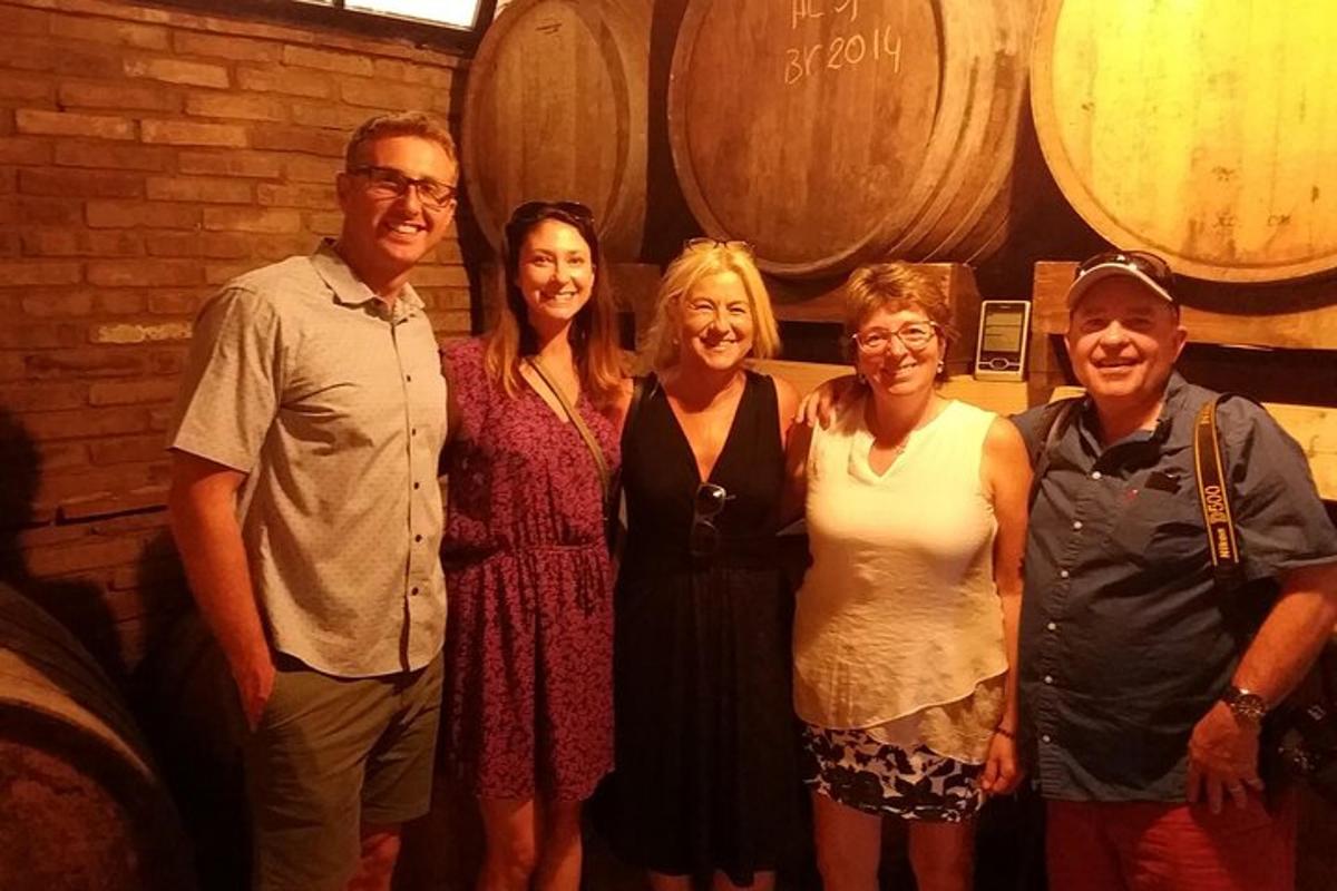 un gruppo di persone in posa per una foto in una cantina vinicola