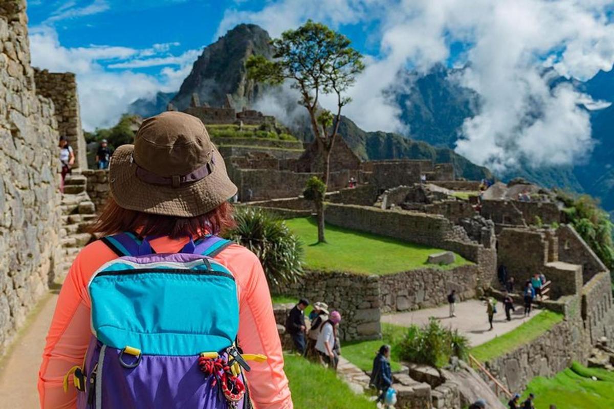 Seljakotiga naine vaatab Machu Picchu varemeid
