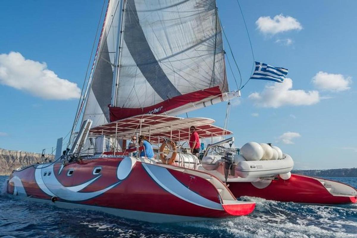una barca a vela rossa e bianca nell'acqua