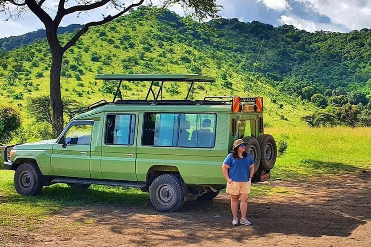un uomo in piedi davanti a una jeep verde