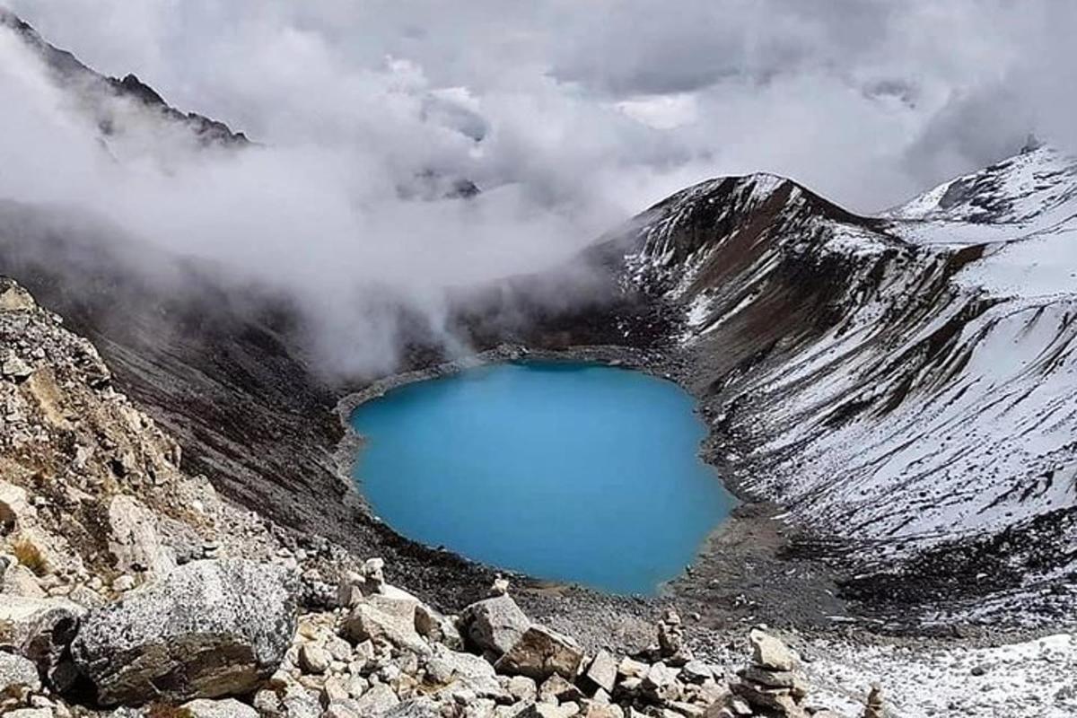 ein blauer See an der Seite eines schneebedeckten Berges