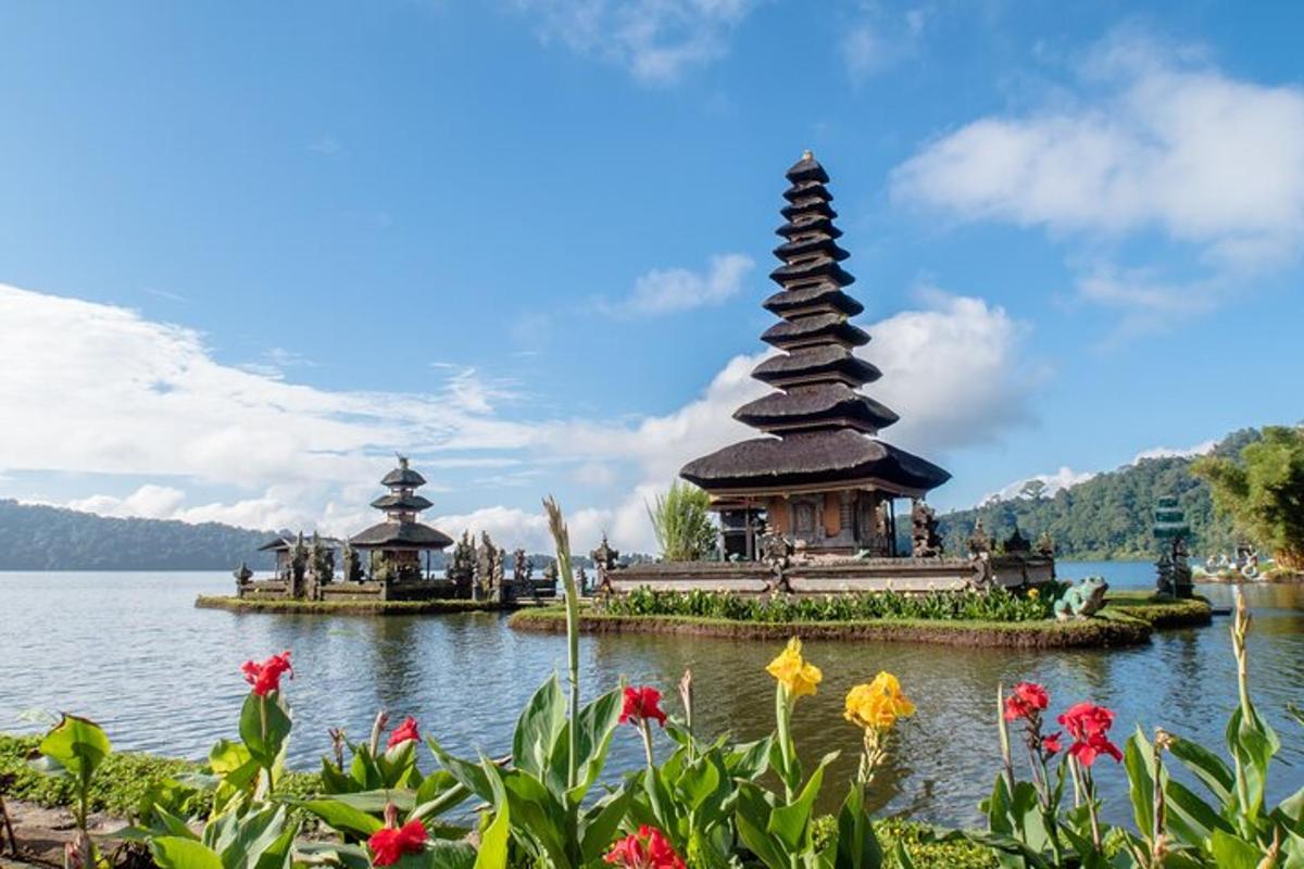 a pagoda in the middle of a lake with flowers