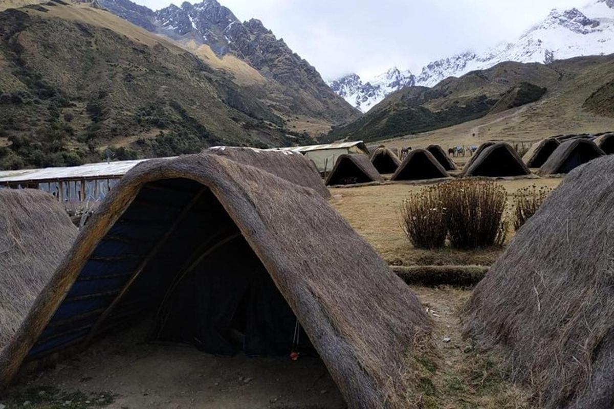 um grupo de cabanas em um vale com montanhas