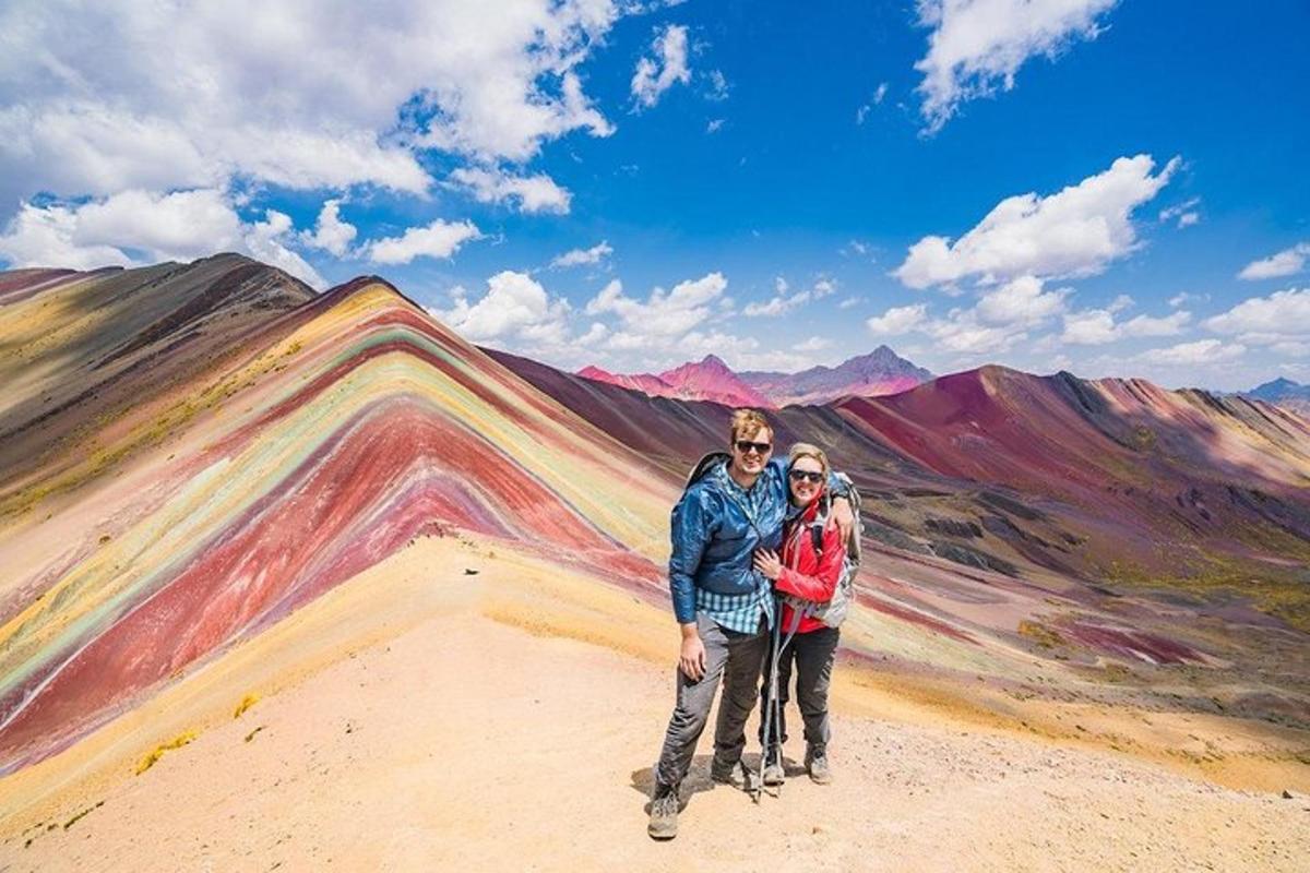 a man and woman standing on top of a mountain