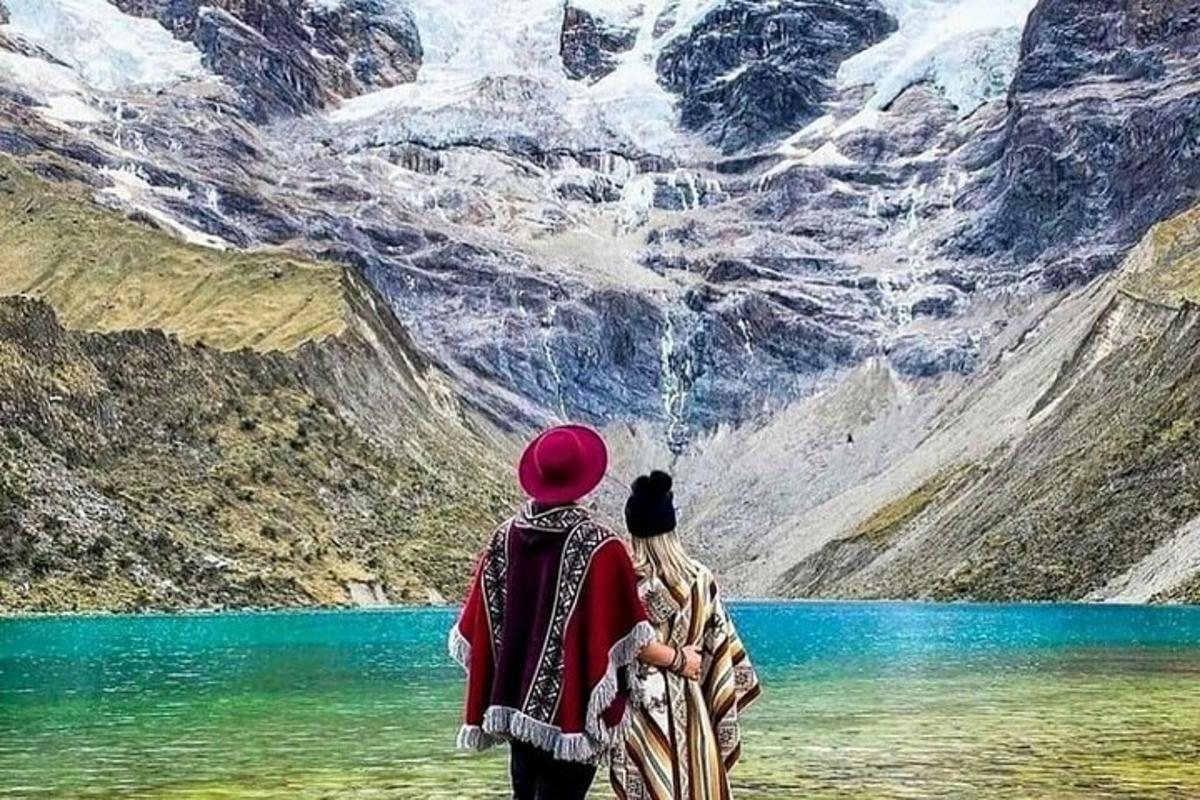 una coppia in piedi davanti a un lago di montagna