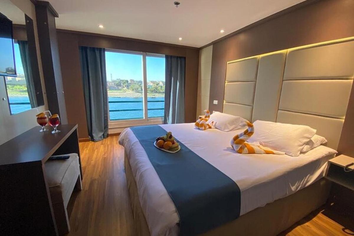 um quarto com uma cama com uma tigela de frutas em cima