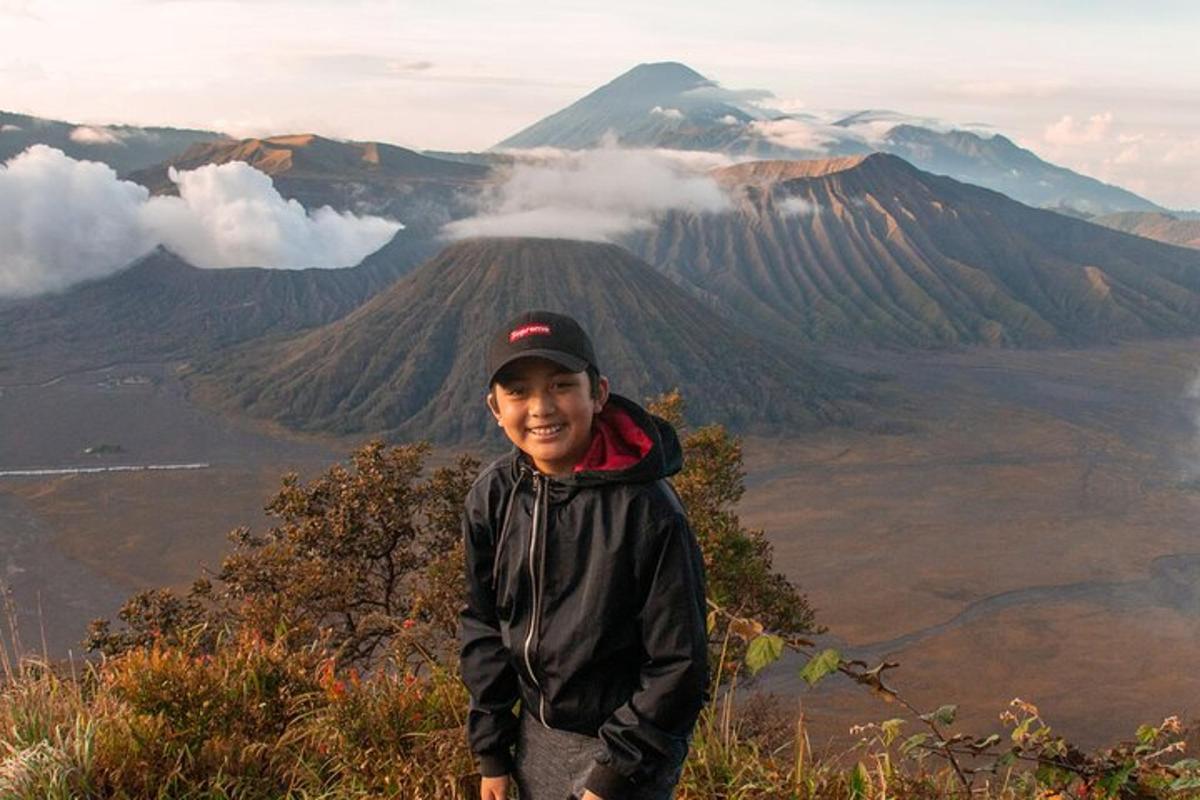 a young boy standing on top of a mountain