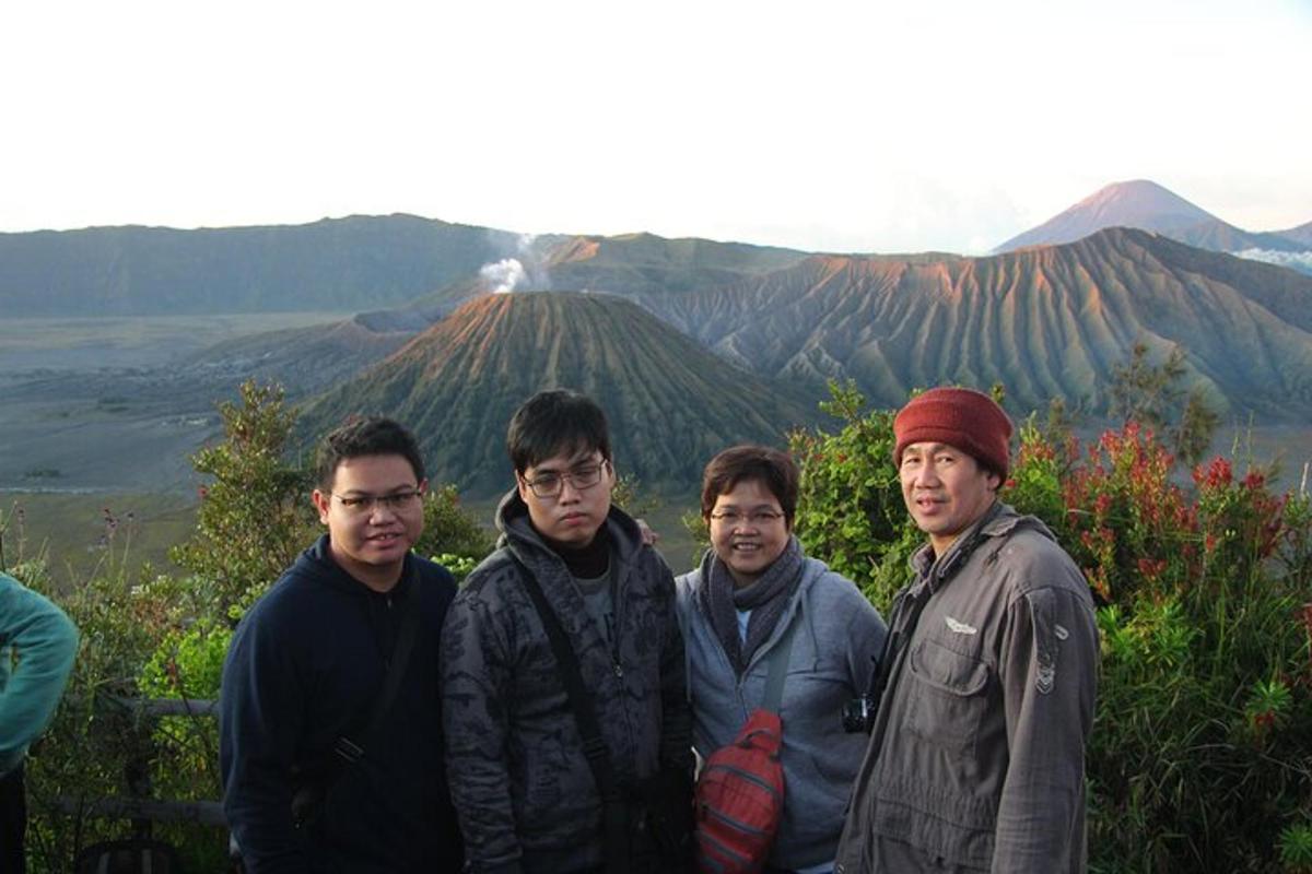 a group of men standing in front of a mountain