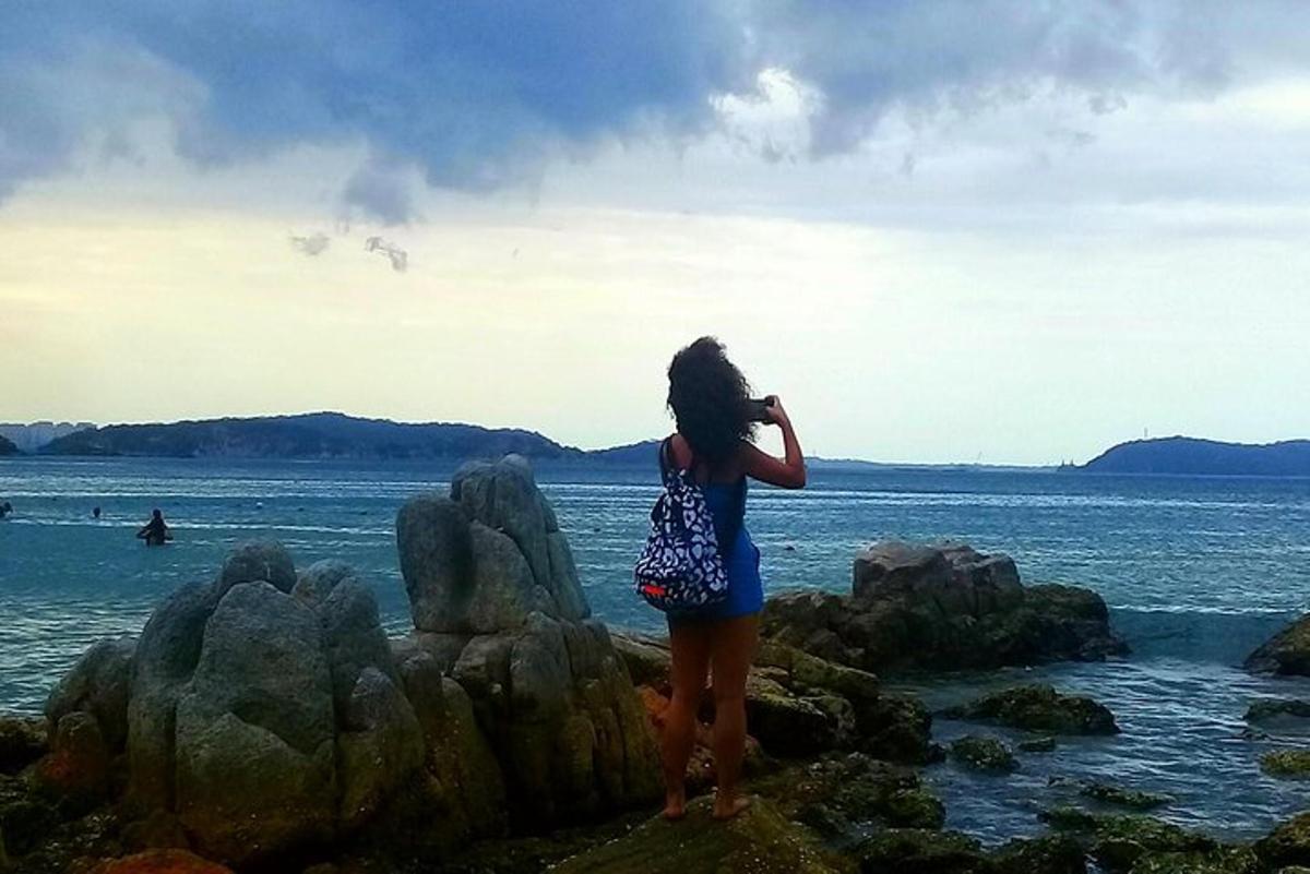 una donna in piedi sulle rocce vicino all'acqua