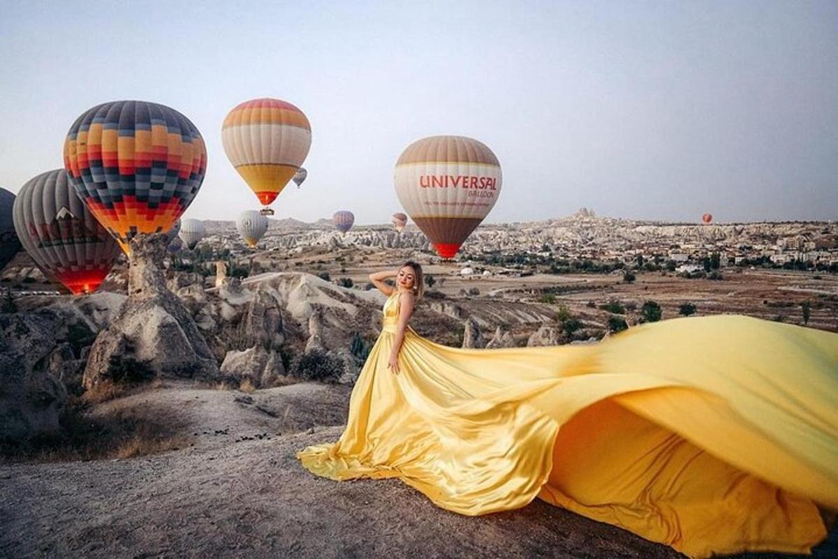 una donna in un vestito giallo che guarda le mongolfiere