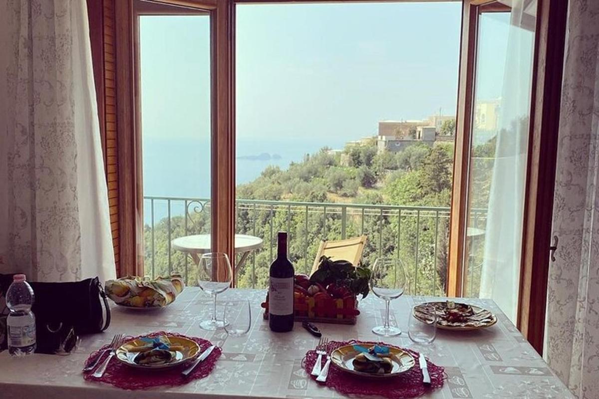 ένα τραπέζι με πιάτα φαγητού και ποτήρια κρασιού και ένα παράθυρο