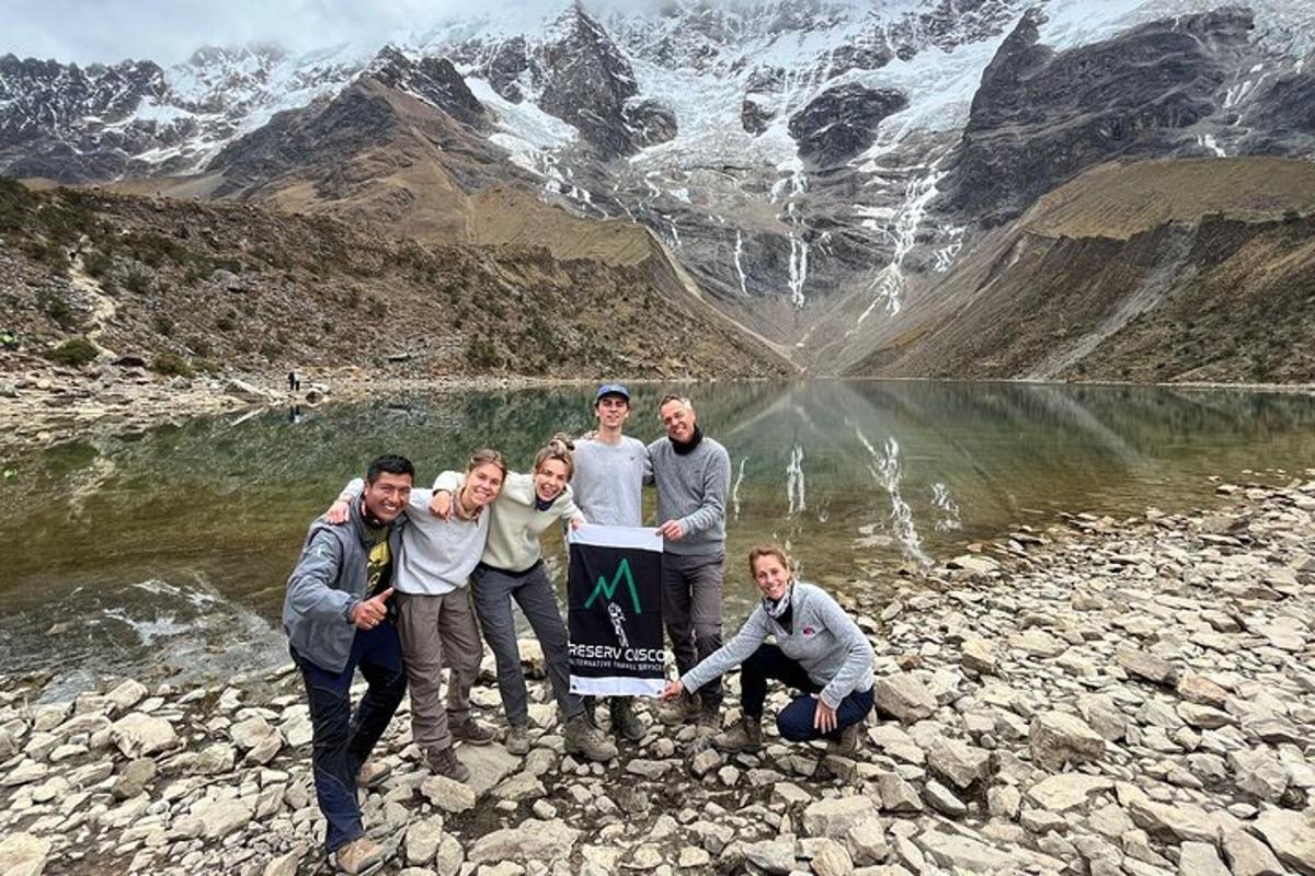 un gruppo di uomini che tengono un cartello davanti a una montagna