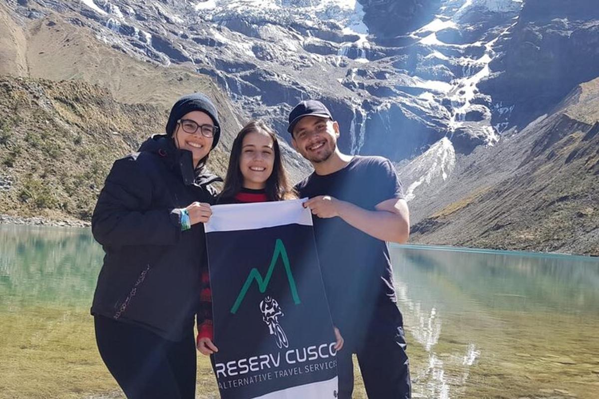 un gruppo di tre persone in piedi di fronte a una montagna
