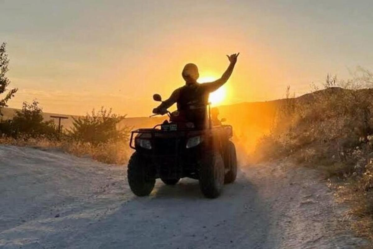 seorang lelaki menunggang basikal quad menyusuri jalan tanah