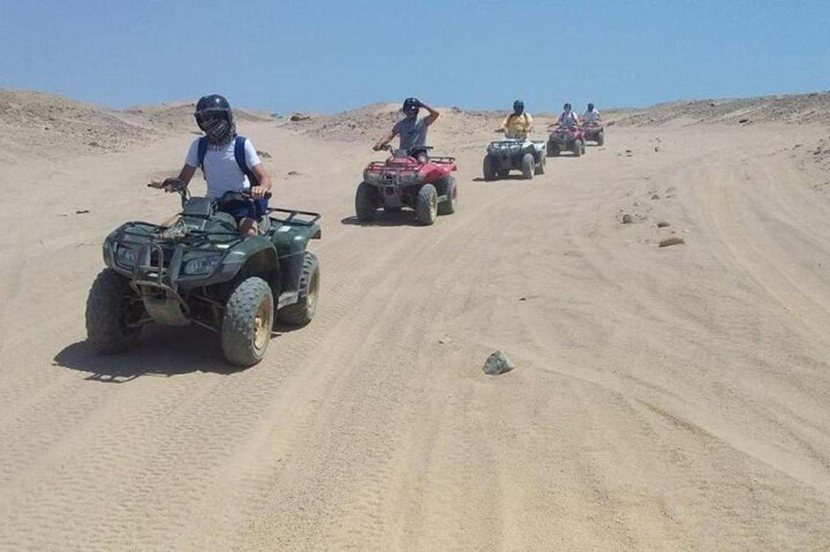 un grup de persones que condueixen quads per un camí de terra