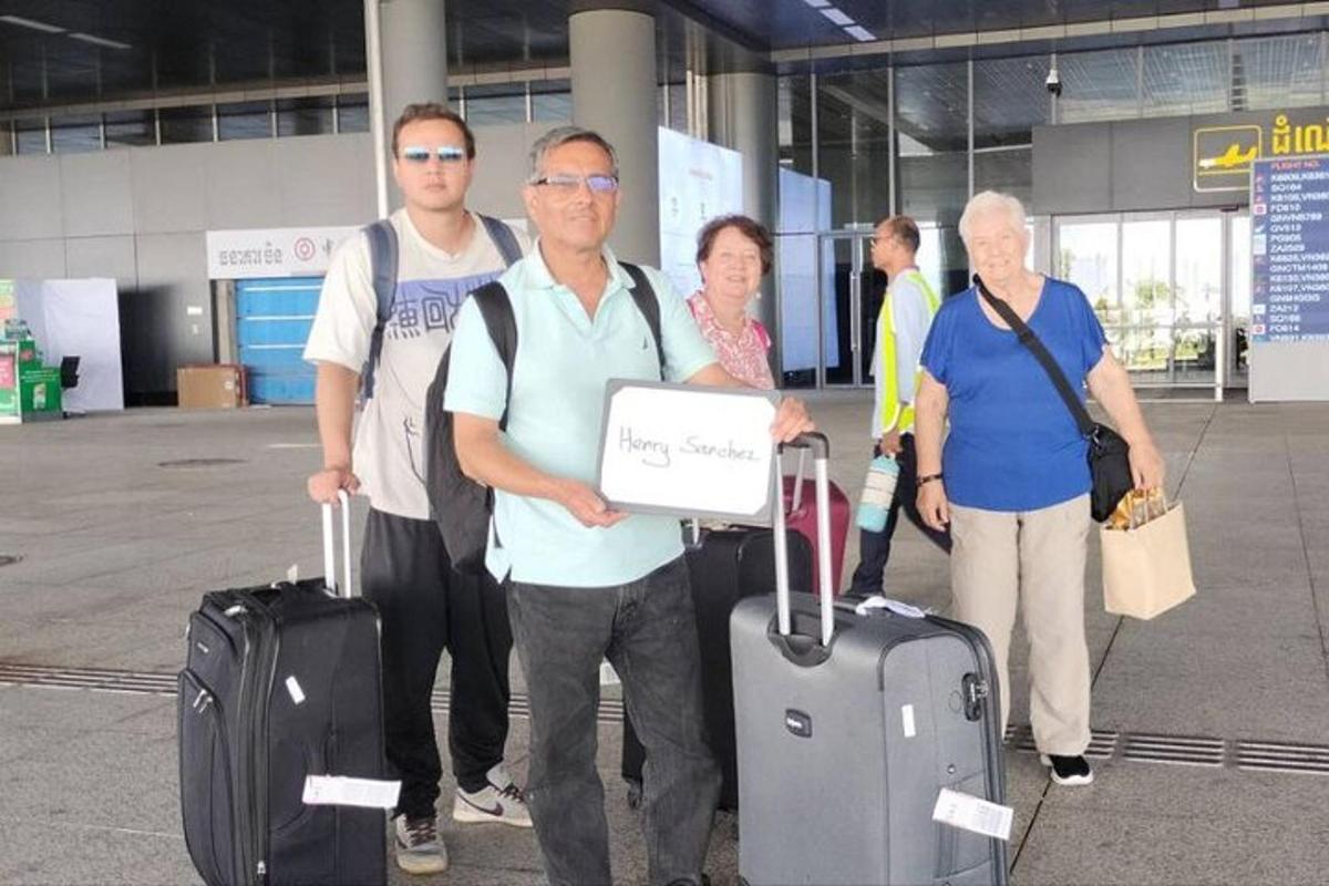 um grupo de pessoas em pé com bagagem em um aeroporto