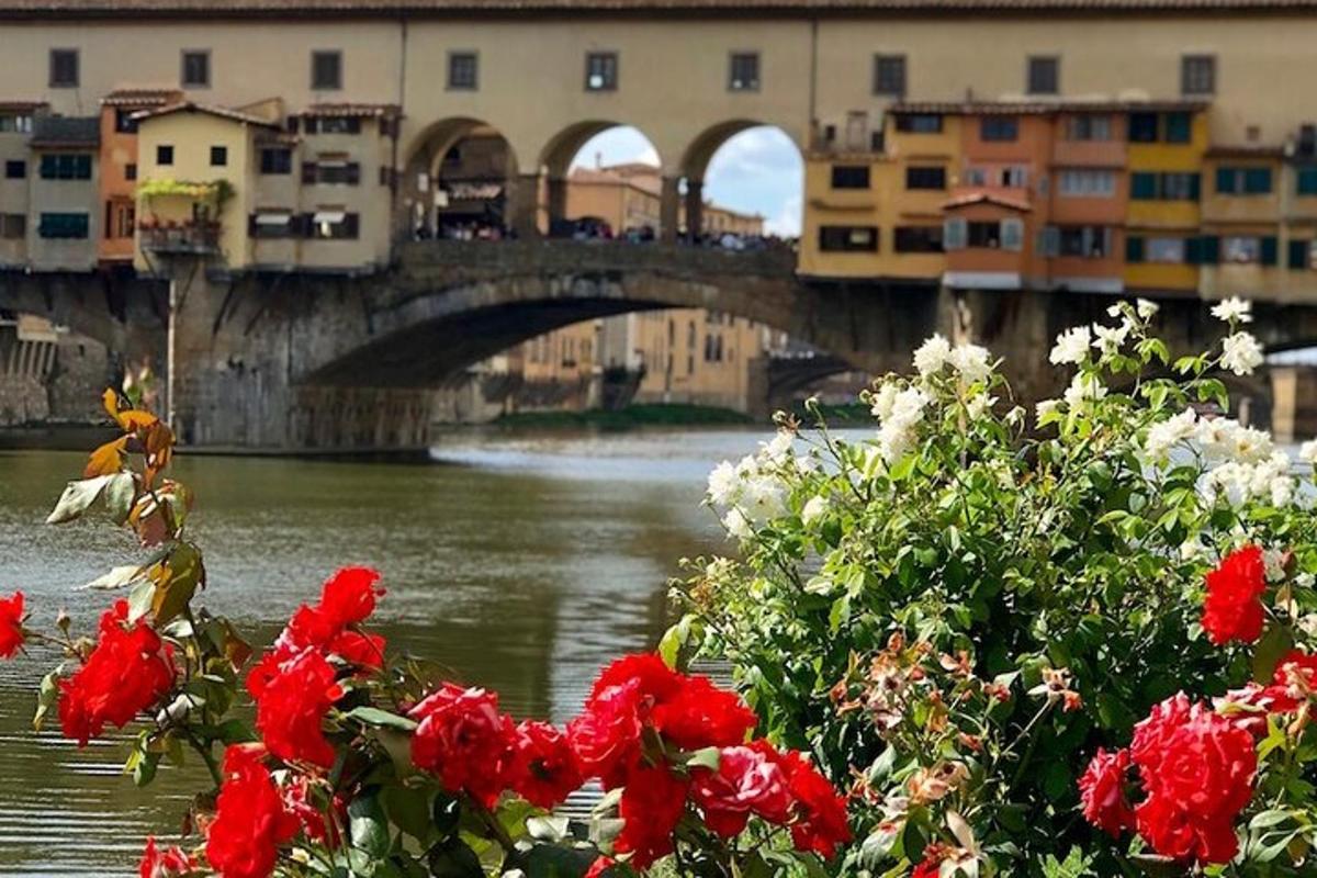 un ponte sopra un fiume con fiori rossi e bianchi