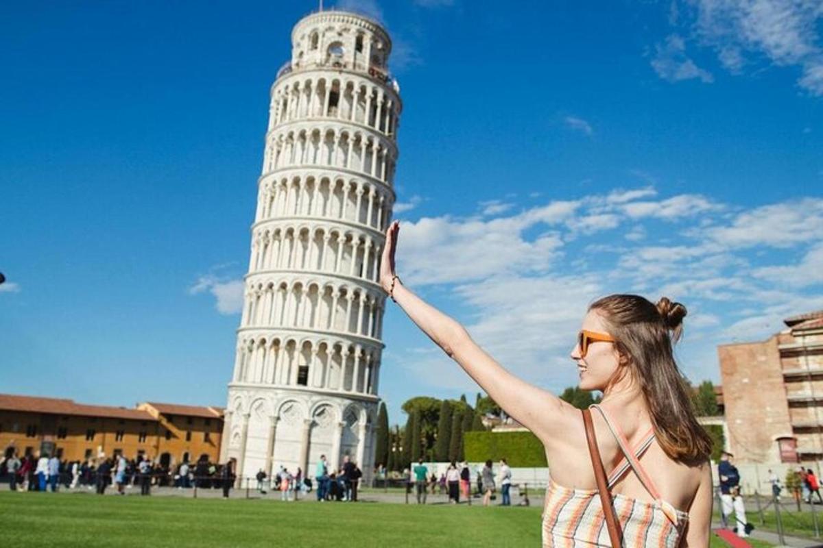 una donna in piedi davanti alla torre pendente