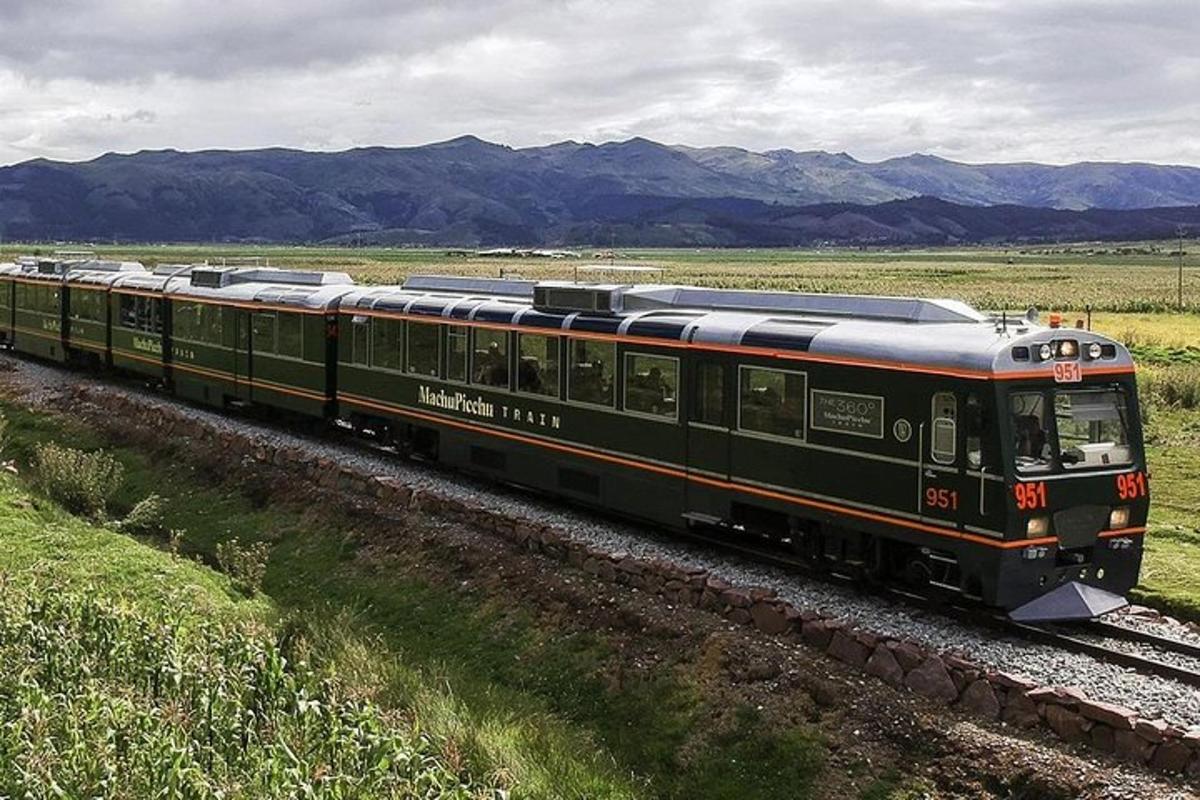 a green train is traveling down the tracks