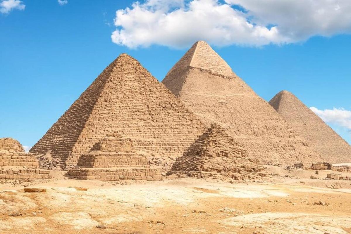 en gruppe pyramider i ørkenen med en blå himmel