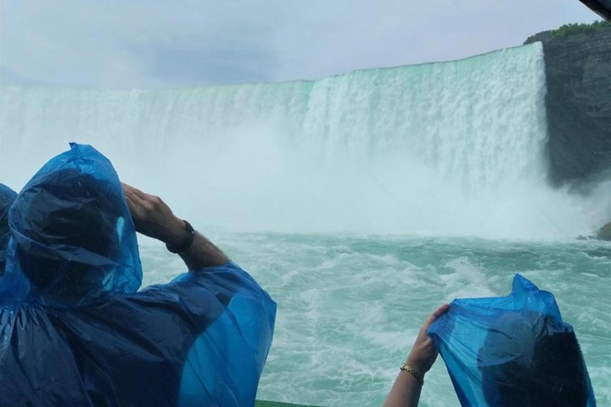 a person in blue garbage bags looking at a waterfall