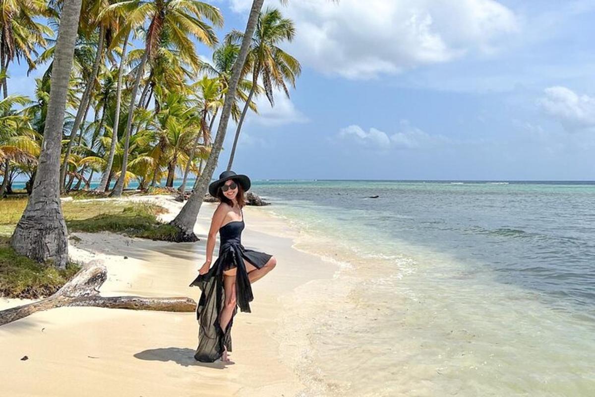 isang babaeng naka itim na damit na nakatayo sa isang beach