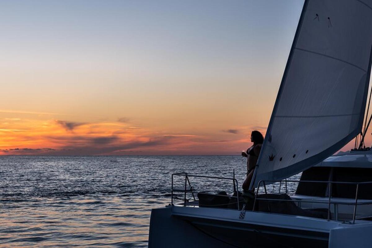 une personne sur un bateau dans l'océan au coucher du soleil