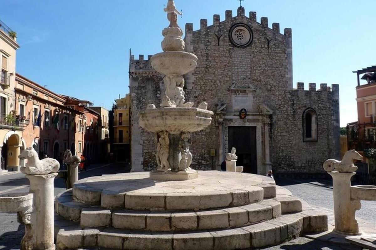 a fountain in front of a building with a clock tower