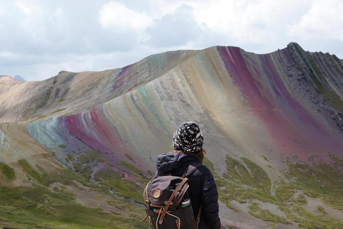 eine Person mit einem Rucksack, die zu einem Berg hinaufblickt