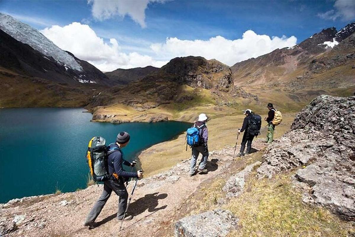 Un grupo de personas caminando por una montaña cerca de un lago.