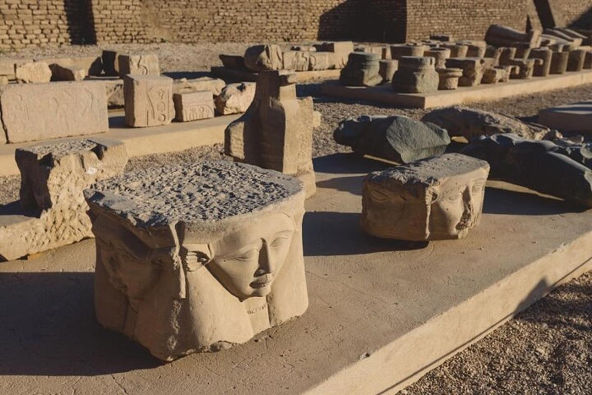 un gruppo di statue di cemento raffiguranti teste su un marciapiede