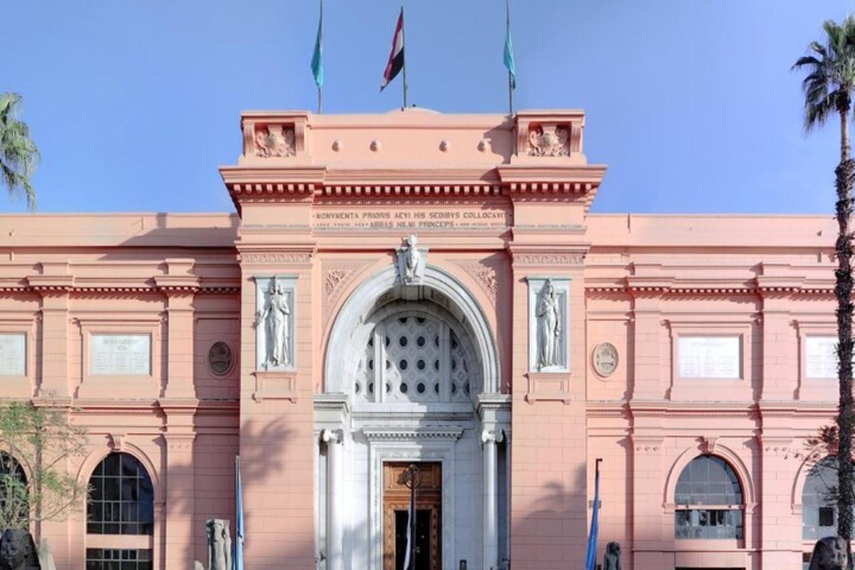 un edificio rosa con due bandiere in cima