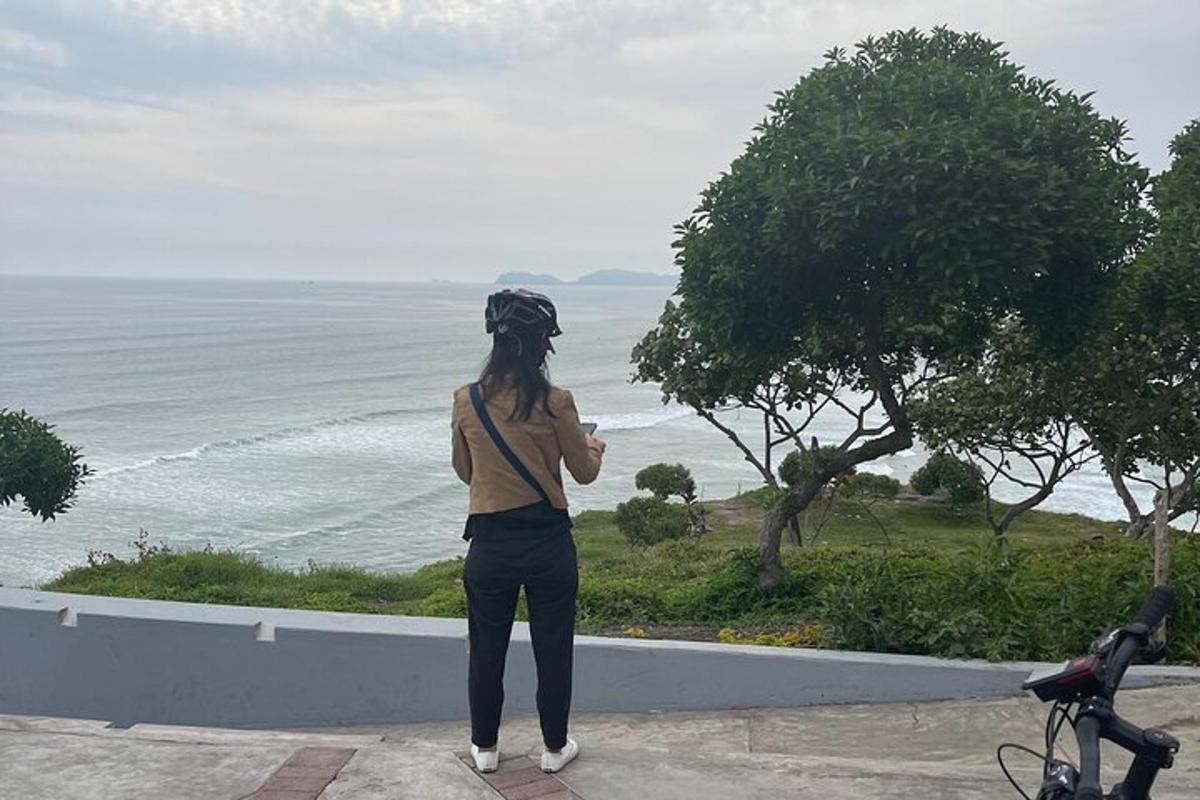 isang babaeng nakatayo sa dingding na nakatingin sa karagatan