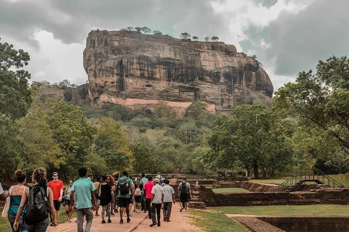 um grupo de pessoas caminhando em frente a uma montanha
