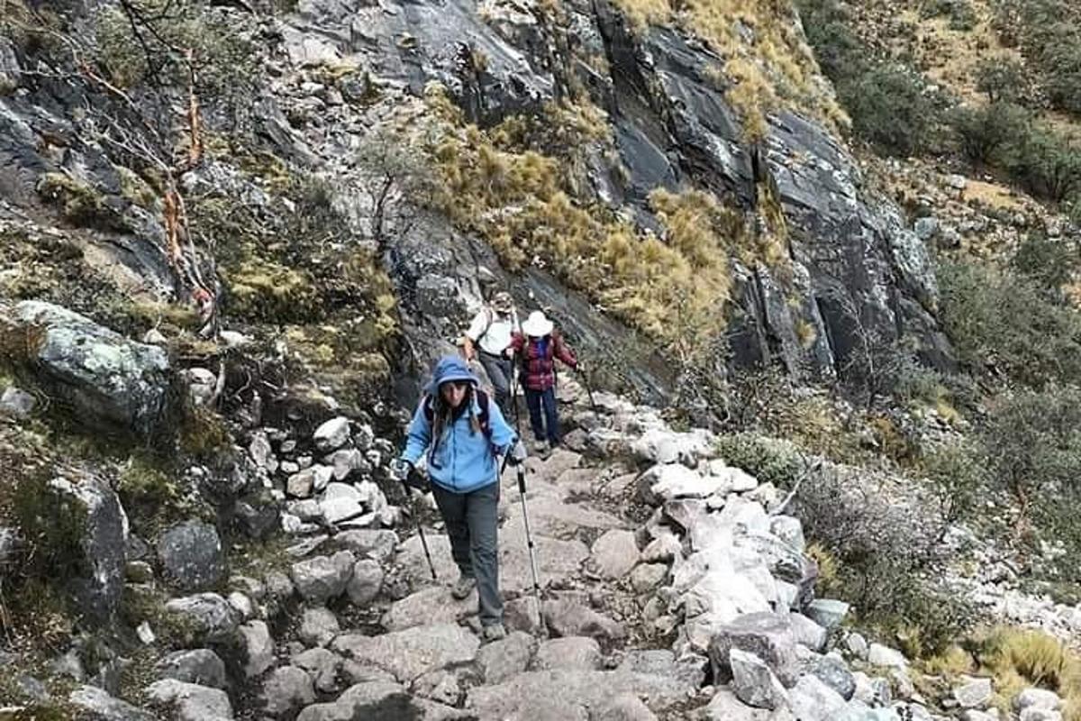 un gruppo di persone che camminano su un sentiero roccioso