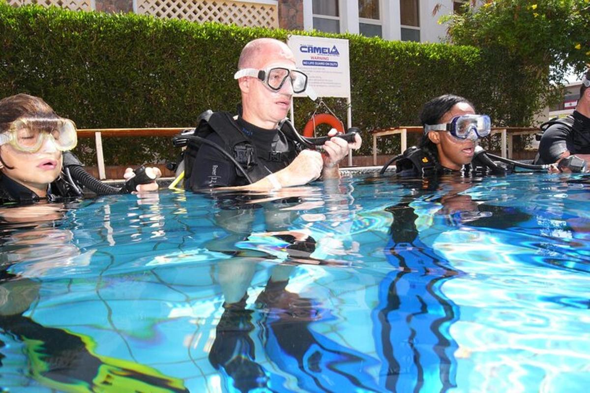 tres persones amb ulleres de natació en una piscina