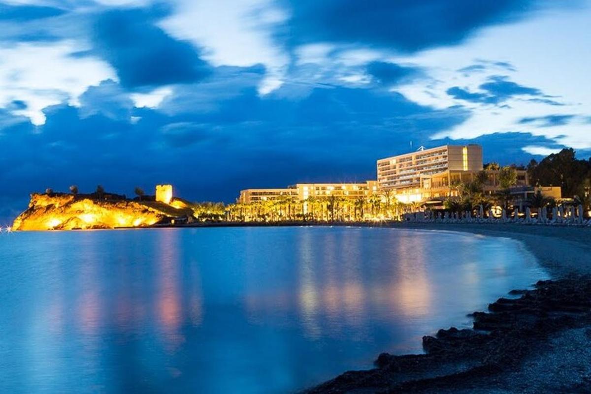 uma vista de uma praia à noite com uma cidade