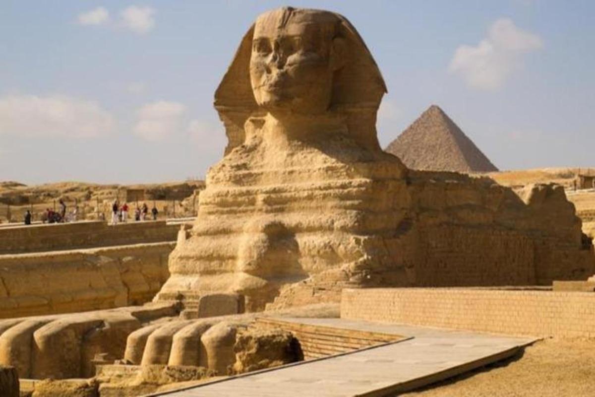 una statua di una sfinge di fronte alle piramidi