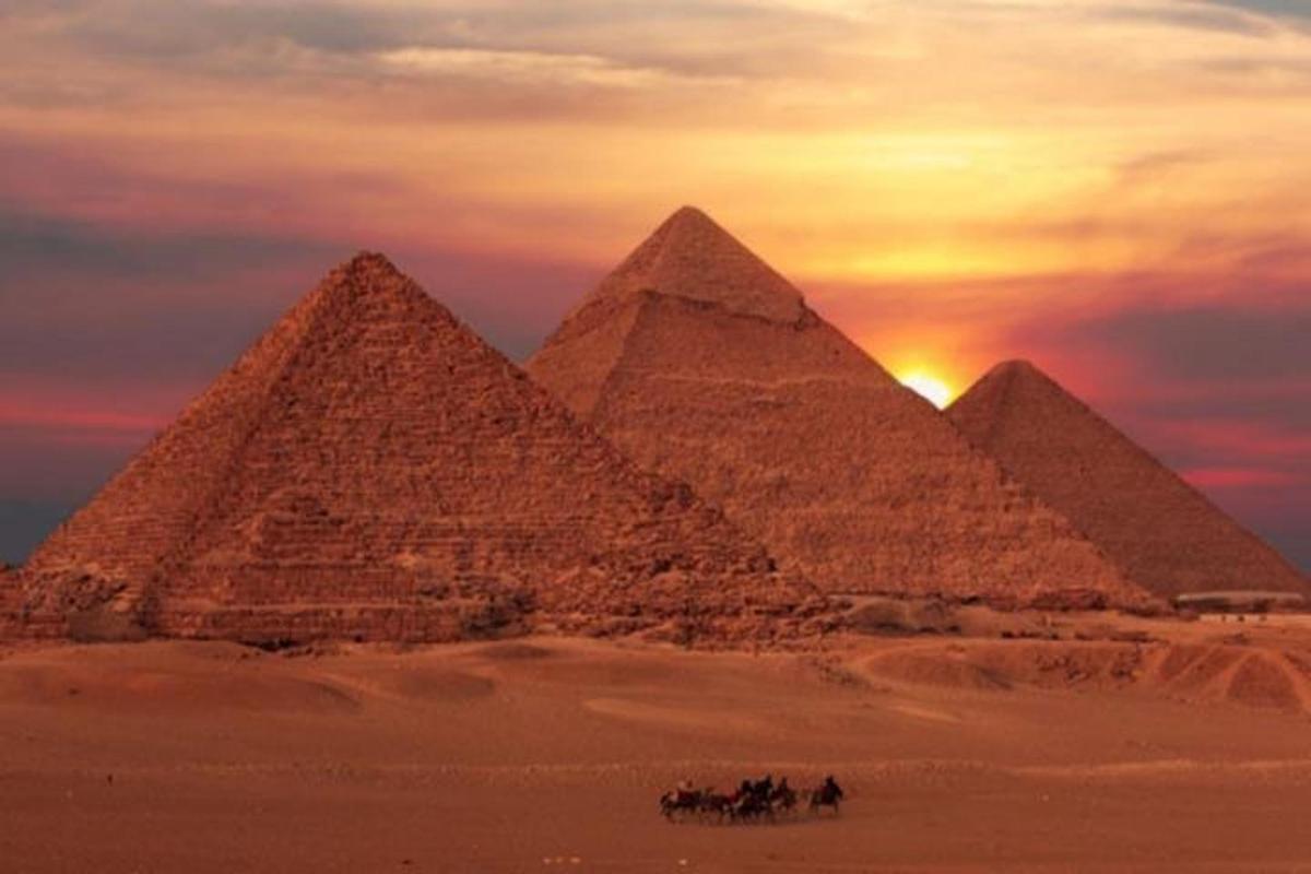 un gruppo di piramidi nel deserto al tramonto
