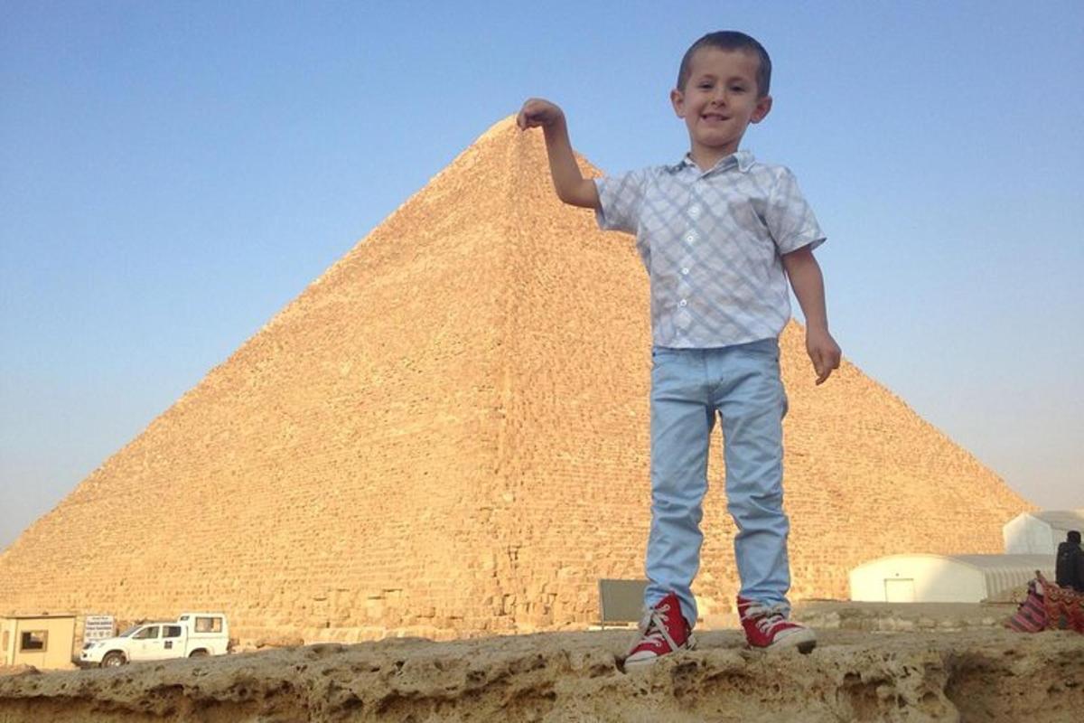 noor poiss seisab püramiidi ees