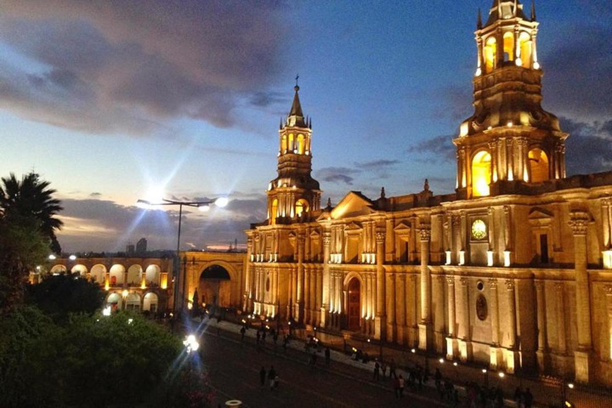 um grande edifício com uma torre do relógio à noite